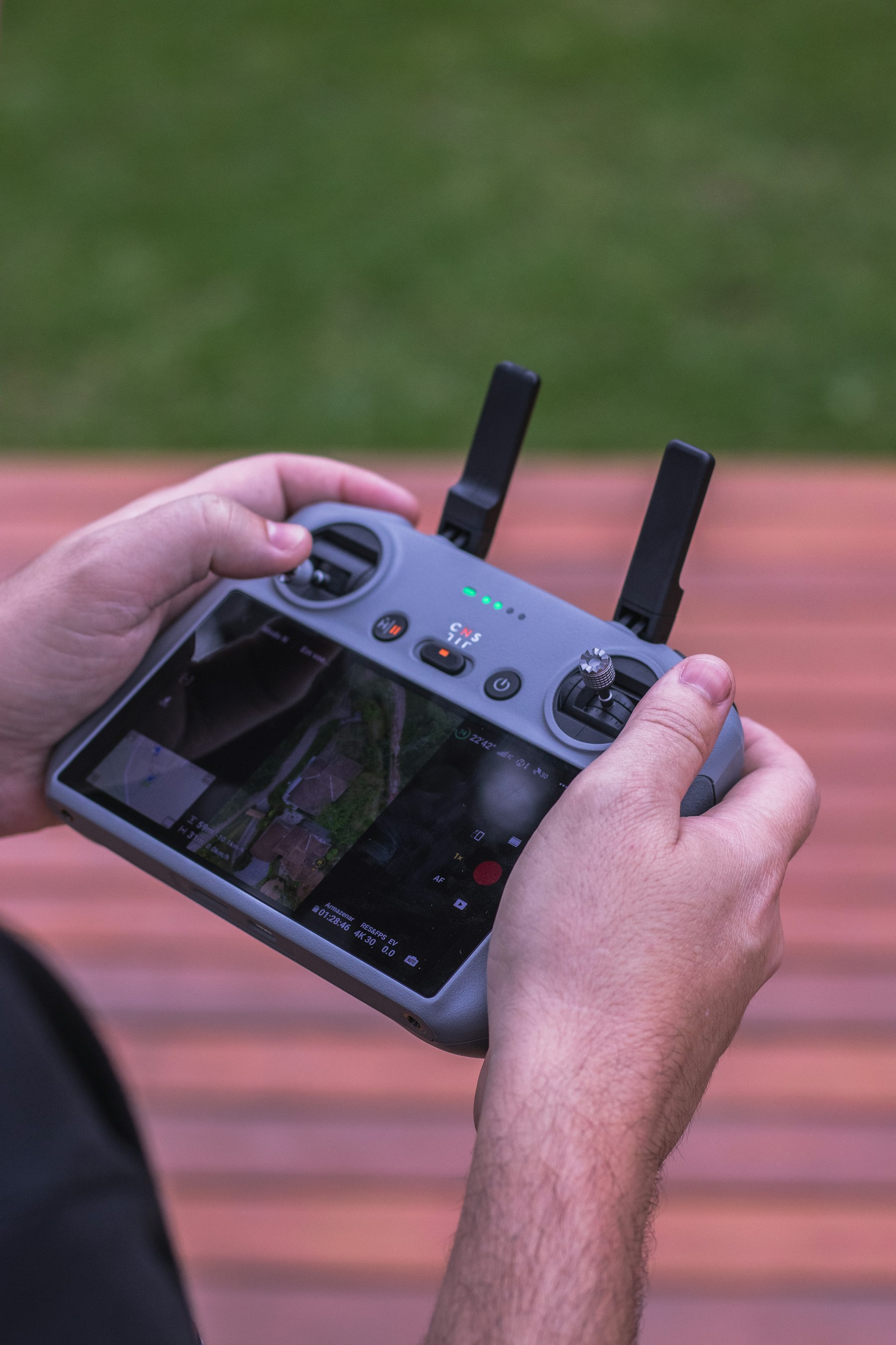 Drone operator using a handheld controller with a live aerial camera feed